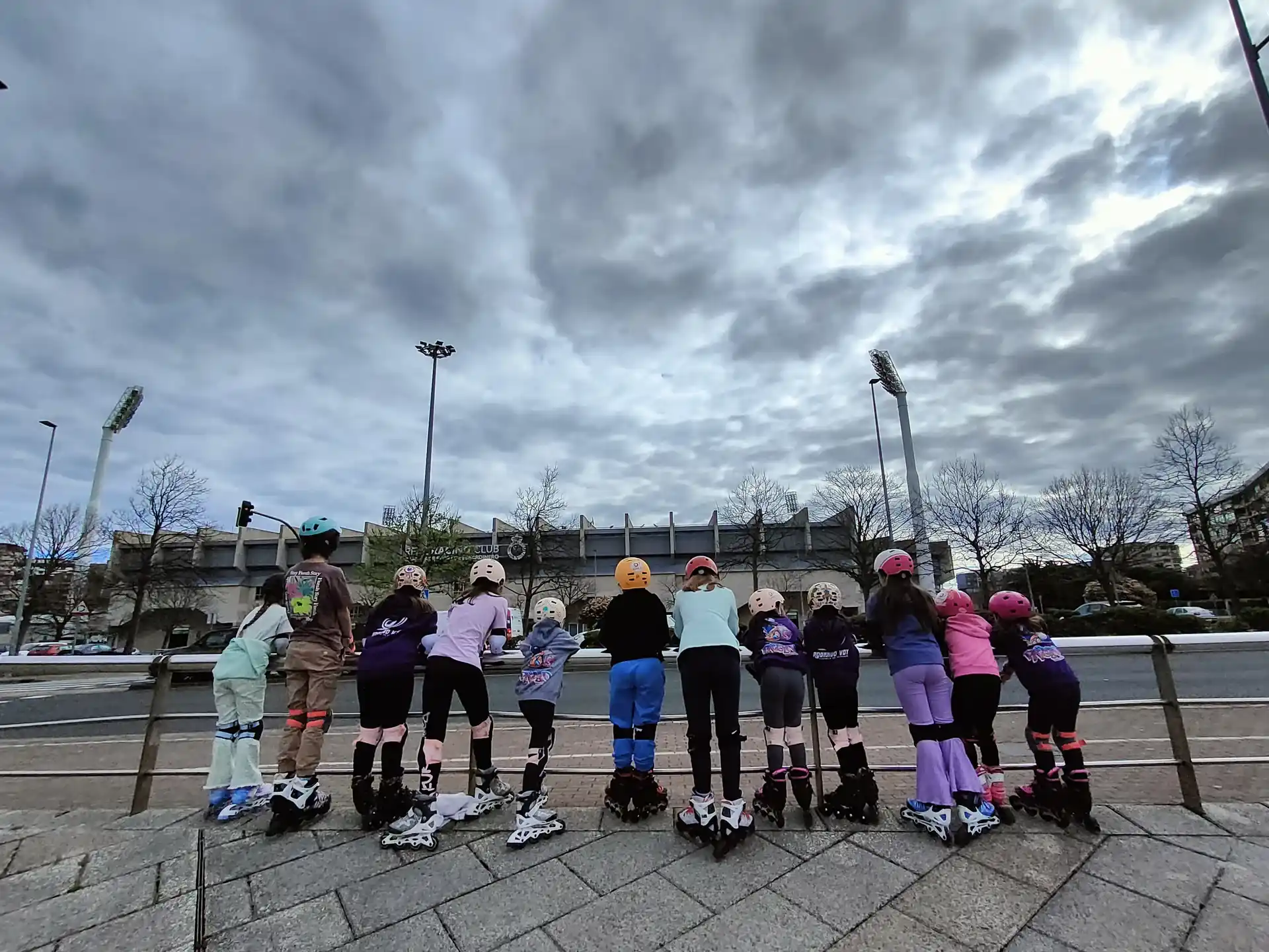 Niño con casco, rodilleras, coderas y muñequeras en clase de patinaje